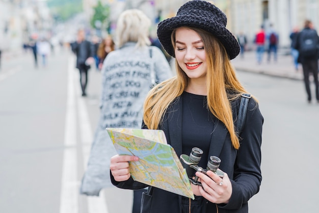 Jovem com mapa e binóculos