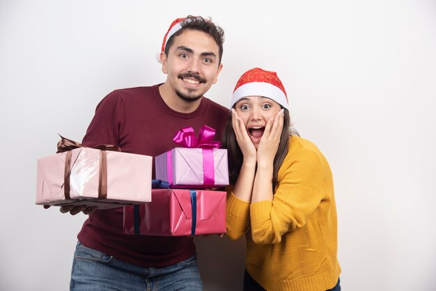 Jovem com mulher posando com presentes de Natal.