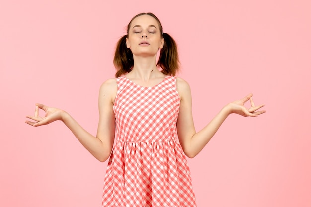 jovem com um lindo vestido rosa com pose de meditação rosa