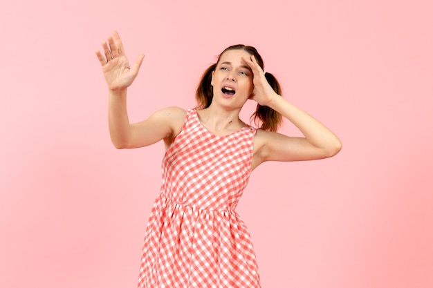 jovem com um lindo vestido rosa com uma expressão dolorosa na cor rosa