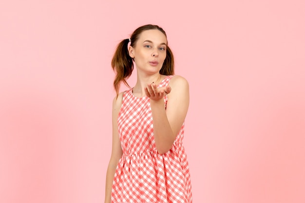 Foto grátis jovem com um lindo vestido rosa mandando beijos no ar rosa