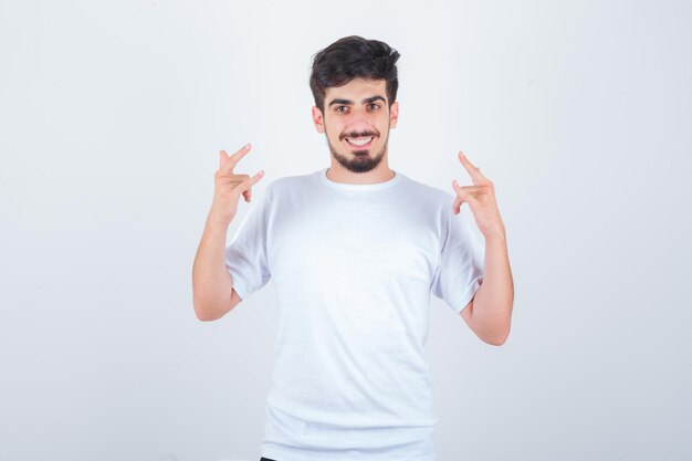 Jovem com uma camiseta mostrando um gesto de "eu te amo" e parecendo alegre