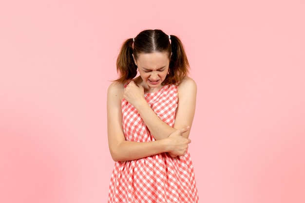 Jovem com vestido rosa fofo machucou o braço rosa