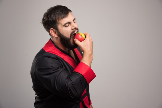 Jovem comendo uma maçã fresca.