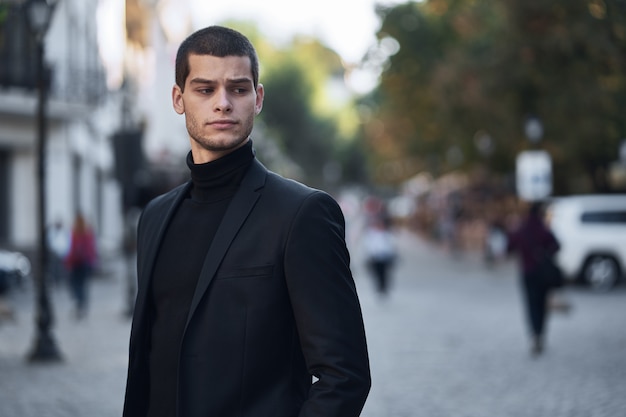 Jovem confiante andando em uma rua da cidade europeia