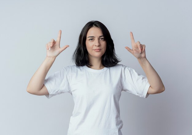 Jovem confiante e bonita caucasiana apontando com os dedos isolados no fundo branco