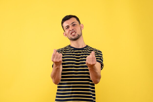 Jovem confuso de vista frontal em uma camiseta listrada de preto e branco amarelo fundo isolado