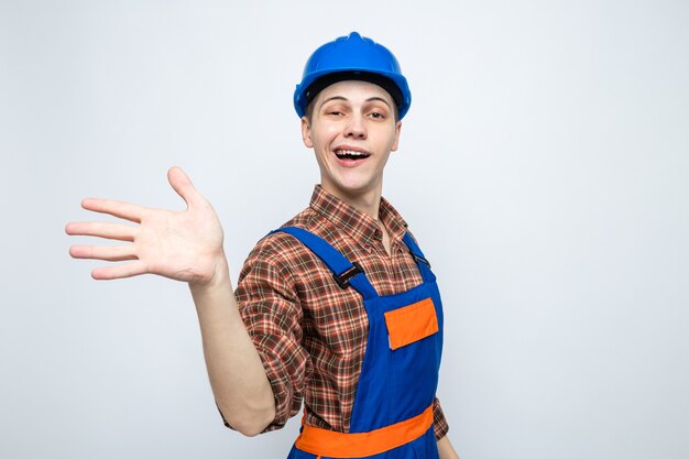 Jovem construtor vestindo uniforme isolado na parede branca