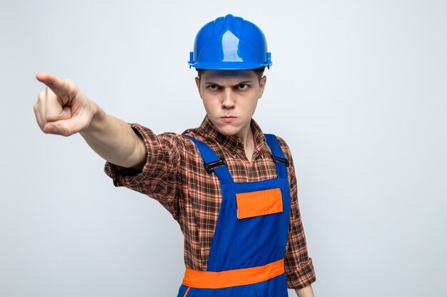 Jovem construtor vestindo uniforme isolado na parede branca