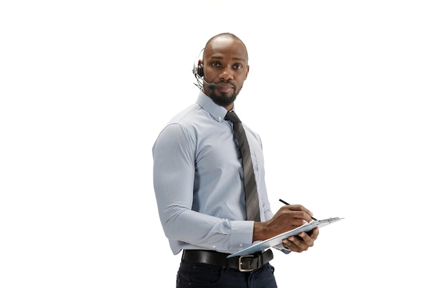 Jovem consultor afro-americano de call center com fone de ouvido isolado em estúdio branco