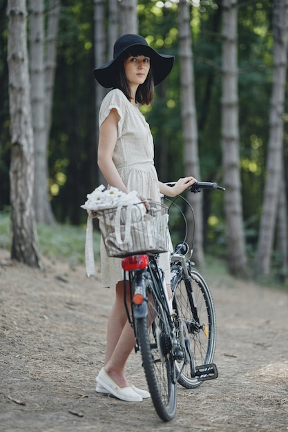 Foto grátis jovem contra o fundo da natureza com bicicleta