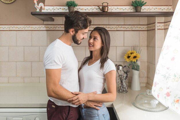 Jovem coule olhando um para o outro na cozinha