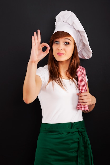 Foto grátis jovem cozinheira mostrando sinal de ok