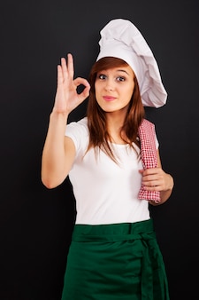 Jovem cozinheira mostrando sinal de ok