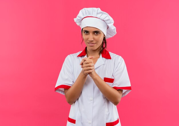 Jovem cozinheira satisfeita usando uniforme de chef, mostrando gesto de aperto de mão com espaço de cópia