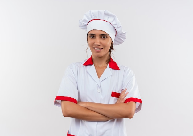 Jovem cozinheira sorridente usando uniforme de chef, cruzando as mãos com espaço de cópia