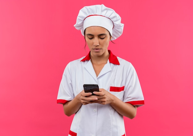 Jovem cozinheira vestindo uniforme de chef, discar o número do telefone com espaço de cópia