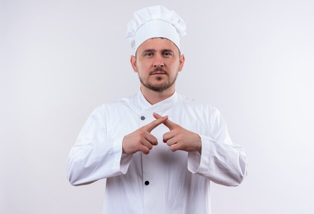 Jovem cozinheiro bonito em uniforme de chef gesticulando para não parecer isolado no espaço em branco