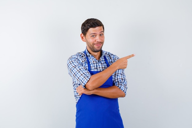 Foto grátis jovem cozinheiro com um avental azul e uma camisa