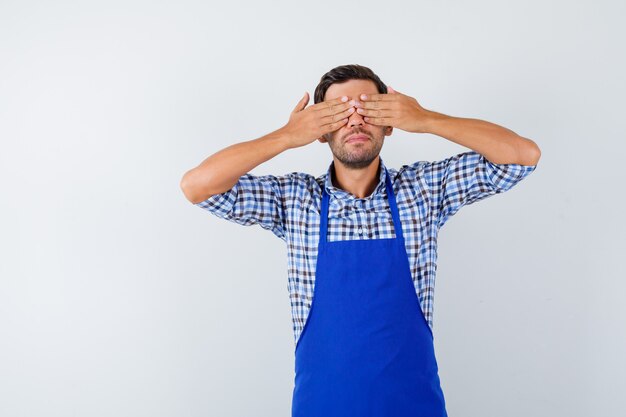 Foto grátis jovem cozinheiro com um avental azul e uma camisa