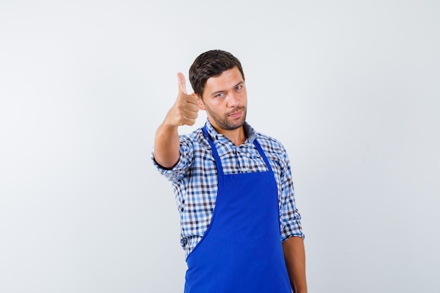 Jovem cozinheiro com um avental azul e uma camisa