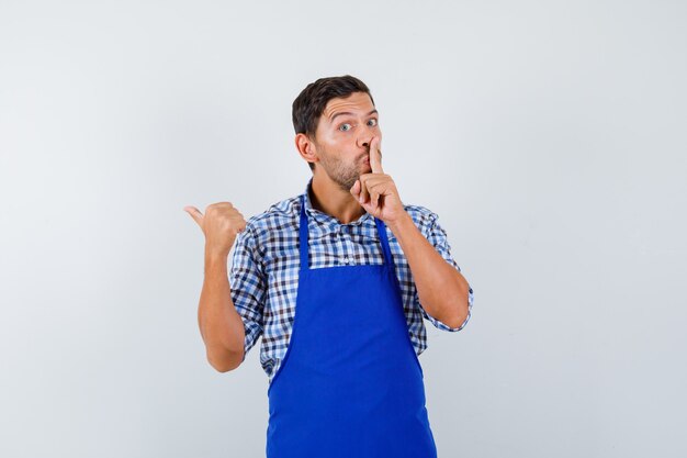 Jovem cozinheiro com um avental azul e uma camisa