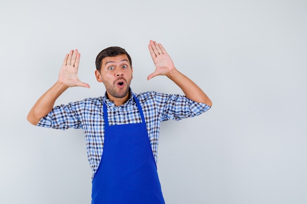 Foto grátis jovem cozinheiro com um avental azul e uma camisa