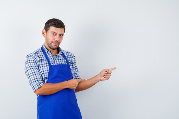 Jovem cozinheiro com um avental azul e uma camisa