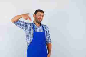 Foto grátis jovem cozinheiro com um avental azul e uma camisa