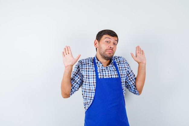 Foto grátis jovem cozinheiro com um avental azul e uma camisa