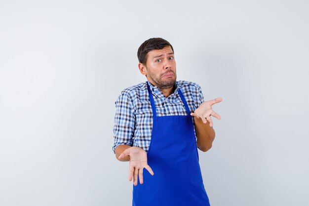 Jovem cozinheiro com um avental azul e uma camisa