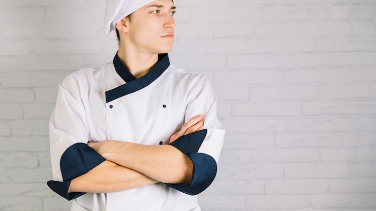 Foto grátis jovem, cozinheiro, em, branca, cruzar braços, peito