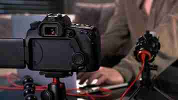 Foto grátis jovem criadora de conteúdo filmando a si mesma usando uma câmera em um tripé e um microfone