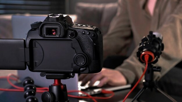 Jovem criadora de conteúdo filmando a si mesma usando uma câmera em um tripé e um microfone