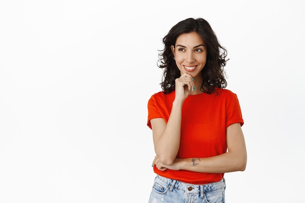 jovem criativa, sorriso branco natural, olhando para o logotipo com uma cara pensativa, tem uma ideia interessante, olhando para o produto, fez sua escolha em branco