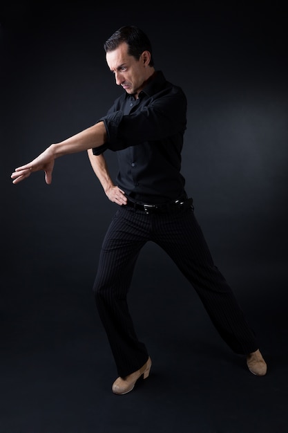 Jovem dançarino de flamenco com lindo vestido no fundo preto.