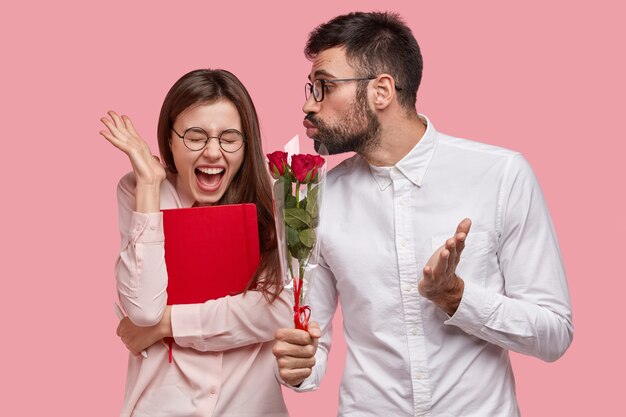 Jovem dando buquê de rosas vermelhas para uma mulher