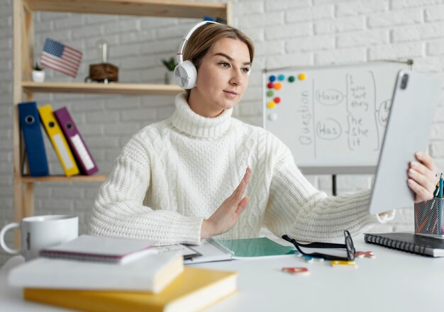 Jovem dando uma aula de inglês online para crianças