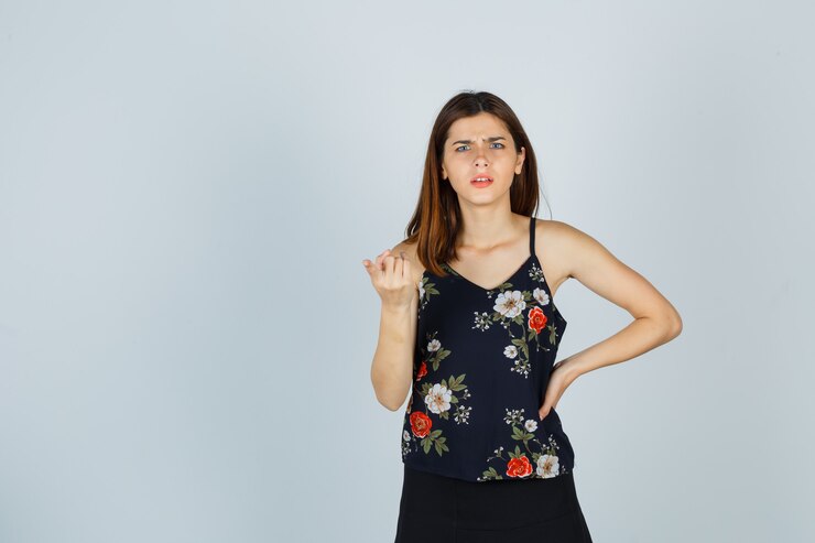 Foto grátis jovem de blusa, saia apontando para longe enquanto franzia a testa e parecia confusa, vista frontal.