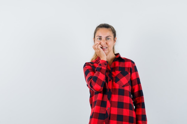 Foto grátis jovem de camisa casual em pé em pose de pensamento e olhando ansiosa, vista frontal.