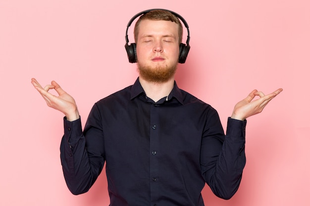 Jovem de camisa preta com fones de ouvido pretos