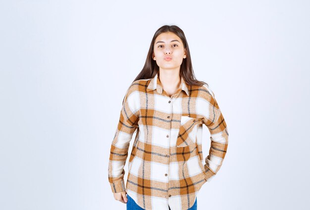 Foto grátis jovem de camisa quadriculada, mandando um beijo no ar.