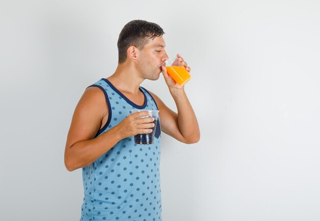 Jovem de camiseta azul segurando e bebendo refrigerante