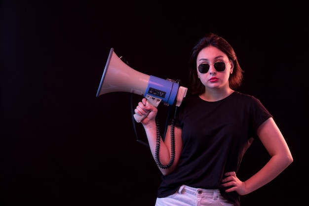 Foto grátis jovem de camiseta preta, segurando o megafone