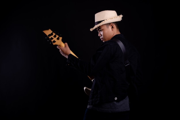 jovem de casaco de couro preto com guitarra elétrica