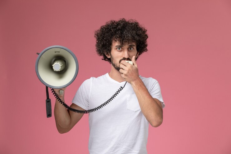 Foto grátis jovem, de frente, dizendo algo com um microfone de mão