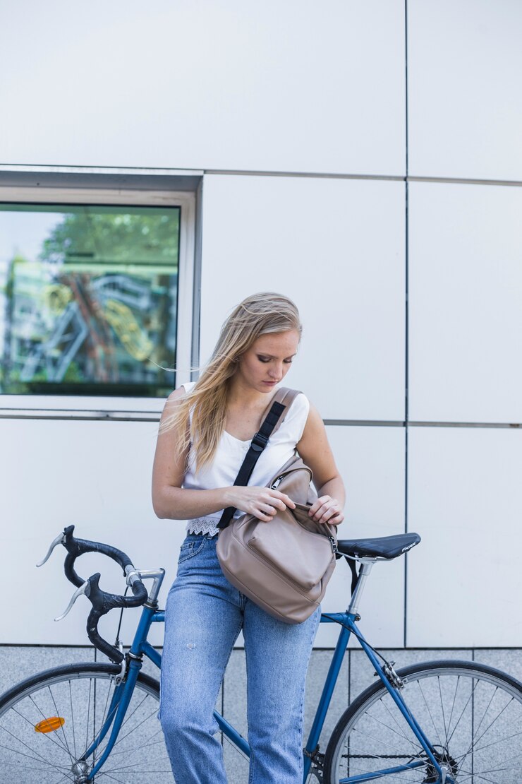 Foto grátis jovem de pé perto da bicicleta olhando para sua mochila