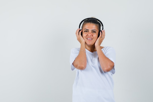 Foto grátis jovem de t-shirt a ouvir música com auscultadores