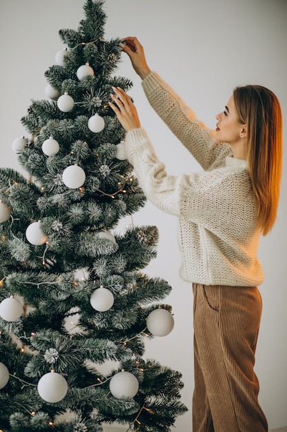 Jovem decorando uma árvore de natal