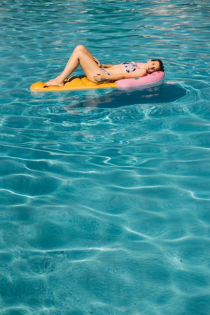 Foto grátis jovem deitada no colchão inflável na piscina